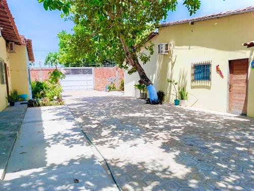a driveway with a tree in front of a house at Casa da Andrea 02 in Barreirinhas