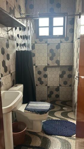 a bathroom with a toilet and a sink at Casa da Barra in Ubatuba