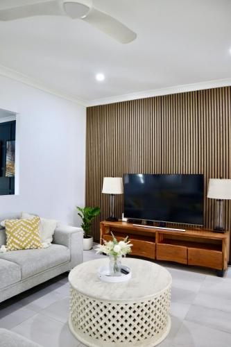 a living room with a large television and a coffee table at Two Williams Estate - Hunter Valley in Cessnock