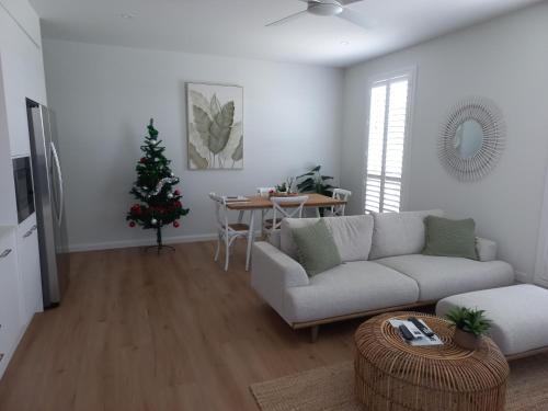 a living room with a couch and a christmas tree at Lillian Waters Retreat in Yamba