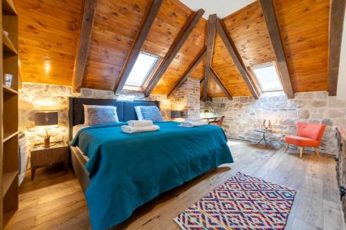 a bedroom with a blue bed in a room with wooden ceilings at Seafront Kotor Bay View Villa NW in Muo