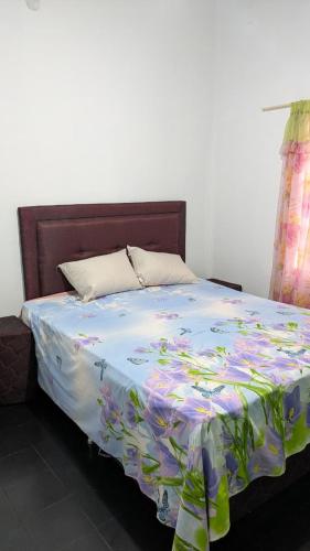 een bed met een bloemdekbed erop bij Diana hotel 2 in Encarnación