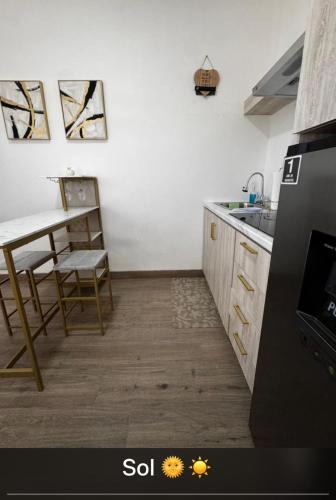 a kitchen with a table and a sink and a refrigerator at Departamento Sol in Heroica Nogales