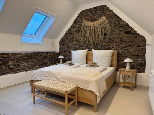 a bedroom with a large bed with a brick wall at Zur Fausenburg in Bruttig-Fankel