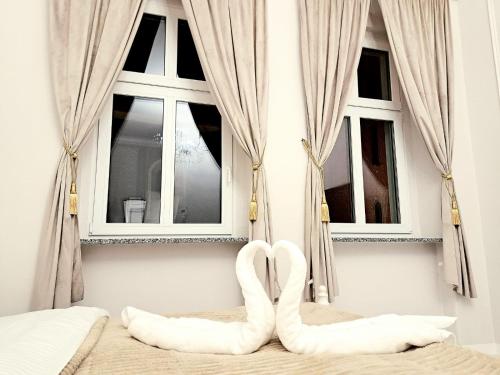 une chambre avec deux coussins en forme de cœur devant deux fenêtres dans l'établissement Poznaj Mickiewicza 2, à Racibórz