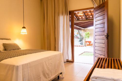 a bedroom with a bed and a door to a patio at Casa Revoada BG PI in Barra Grande