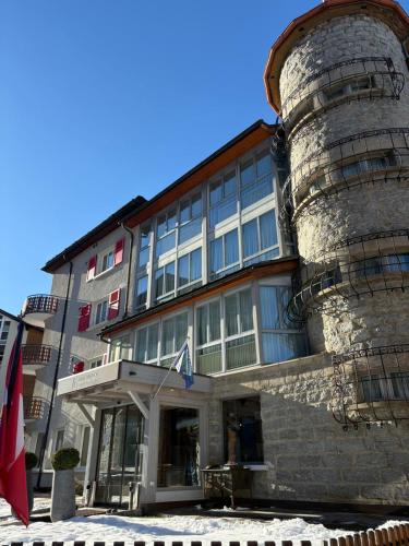 a large stone building with a flag in front of it at Lifestyle & Spa Hotel Grächerhof in Grächen