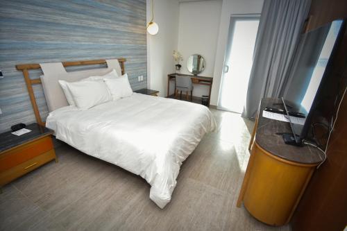 a bedroom with a bed and a flat screen tv at Hotel Dublé in Navojoa