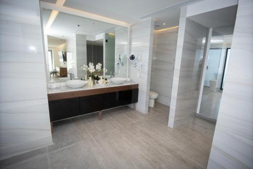 a bathroom with two sinks and a large mirror at Hotel Dublé in Navojoa