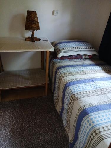 una camera da letto con un letto e un tavolo con una lampada di casa a Bocaina de Minas