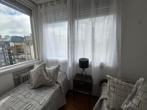 une chambre avec un lit et une grande fenêtre dans l'établissement Departamento cerca de la playa a tres cuadras dela playa, à Mar del Plata