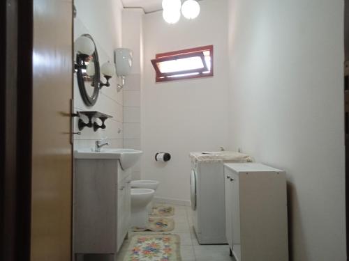 een witte badkamer met een wastafel en een toilet bij appartamento Gabry in Dolianova