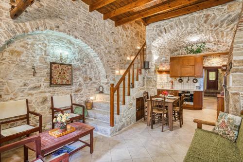 een keuken en een woonkamer met een stenen muur bij Medieval Villa Philoxenia in Kalamoti