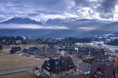 a small town with mountains in the background and a city at Apartamenty Premium Rysulówka in Kościelisko