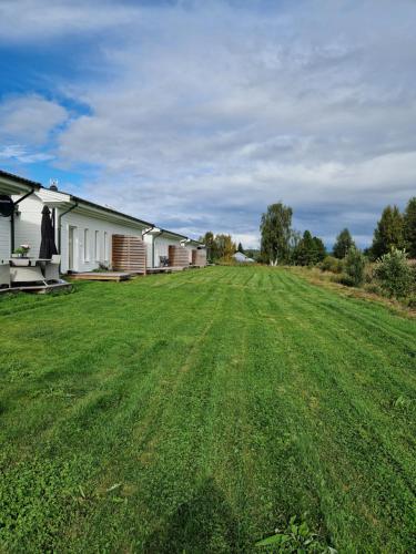 a large grass field in front of a house at Arcticstay 25A in Pajala