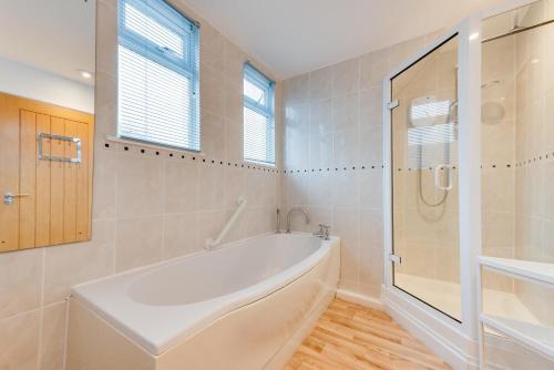 a white bathroom with a tub and a shower at 4 Bed in Langton Matravers oc-wy548 in Langton Matravers