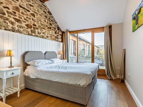 een slaapkamer met een bed en een groot raam bij 3 Bed in Umberleigh 09092 in Umberleigh Bridge