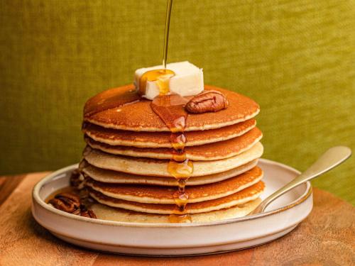 a stack of pancakes on a plate with butter and nuts at Mercure Aix-les-Bains Domaine de Marlioz Hôtel & Spa in Aix-les-Bains
