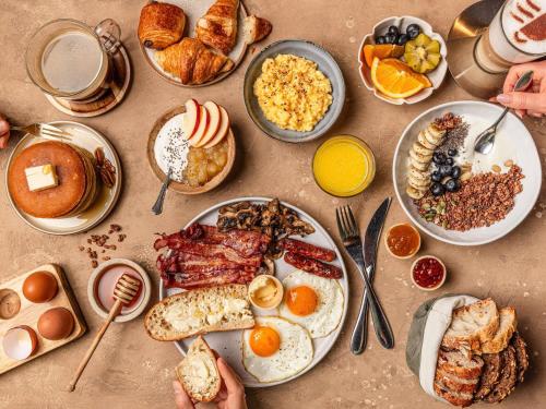 a table filled with plates of breakfast foods and drinks at Mercure Aix-les-Bains Domaine de Marlioz Hôtel & Spa in Aix-les-Bains