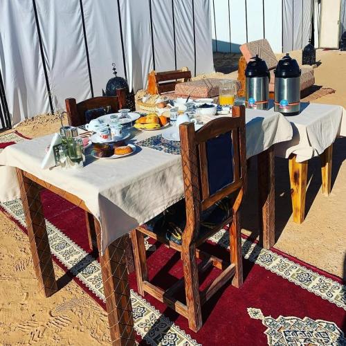 een tafel in een tent met eten erop bij Diamante Luxury Camp in Merzouga