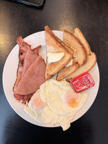 a plate of breakfast food with eggs bacon and toast at Hotel Nieto Express in Matamoros