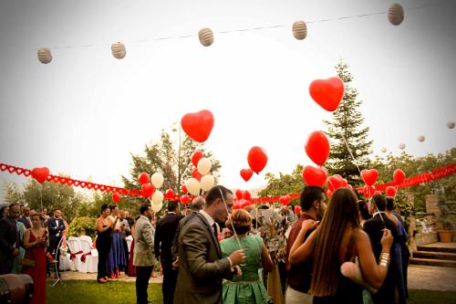 un grupo de personas de pie bajo globos de corazón rojos en Hotel Zerbinetta, en Dílar
