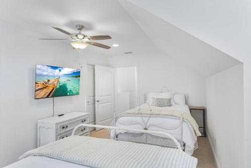 Camera bianca con 2 letti e un ventilatore a soffitto. di Marsh Views On Holly a Ebo Landing