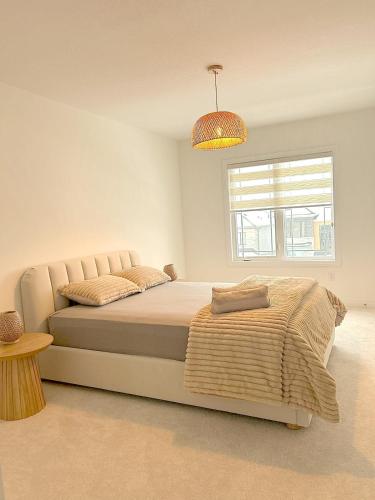a white bedroom with a bed and a window at Nordic Three Brantford in Brantford