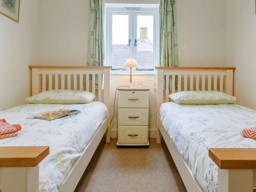 zwei Einzelbetten in einem Schlafzimmer mit Fenster in der Unterkunft 2 Bed in West Knoyle 52105 in West Knoyle