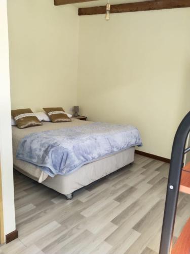 een slaapkamer met een bed en een houten vloer bij Casa Dorada in San Pedro de Atacama