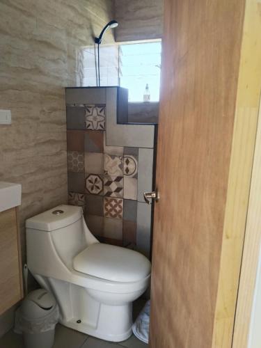 een badkamer met een toilet en een aantal tegels bij Casa Dorada in San Pedro de Atacama