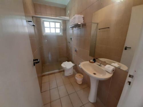 um banheiro com pia, chuveiro e vaso sanitário em Pousada Pantai Maresias em Maresias