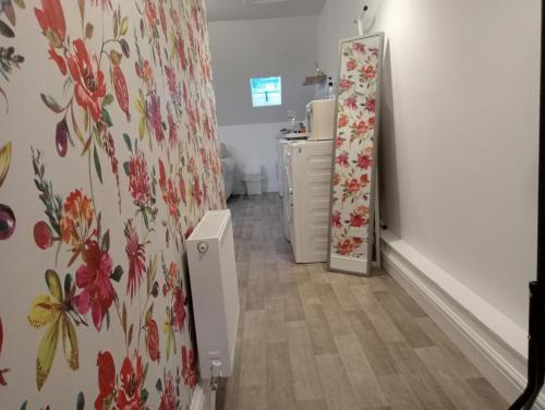 Ein Zimmer mit Kommode und geblümter Tapete. in der Unterkunft Hill View Studio in Hawick