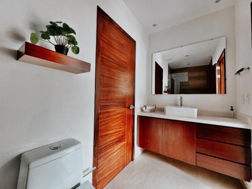 a bathroom with a sink and a wooden door at OVATA 401- Zona Romántica in Puerto Vallarta