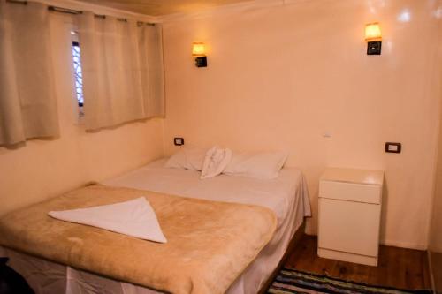 a bedroom with a bed with white sheets and a window at Floating Hotel- Happy Nile Boat in Luxor