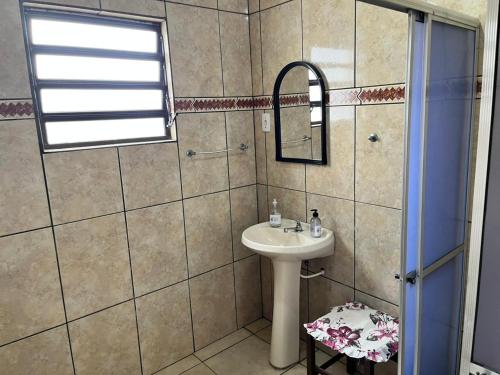 een badkamer met een wastafel en een spiegel bij Pousada La Marea in Rio Grande