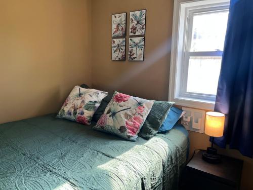 een slaapkamer met een bed met kussens en een raam bij The Bay House in Shady Side