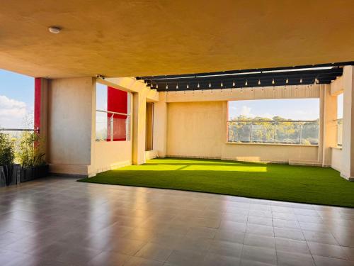 a living room with a green carpet and windows at Safari Cozy Homes in Nairobi