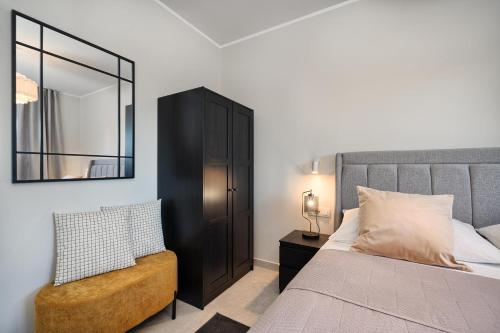 a bedroom with a bed and a mirror and a chair at Tina's Tiny Beach House in Slatine