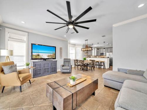 een woonkamer met een bank en een plafondventilator bij Blue Coconut in Destin