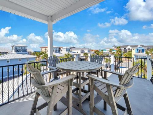 een tafel en stoelen op een balkon met uitzicht op de oceaan bij Blue Coconut in Destin
