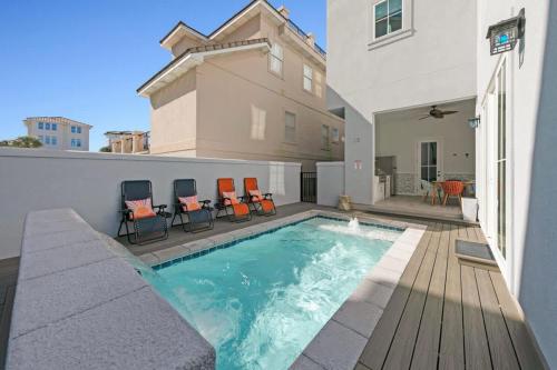 een zwembad met stoelen en een huis bij Azul Atlantica in Destin