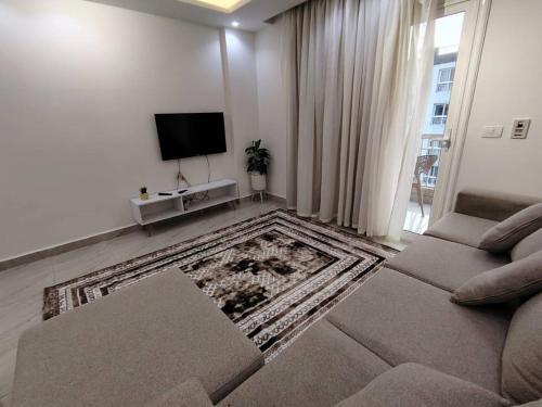 a living room with a couch and a flat screen tv at مدينتي in Kafr Salīm