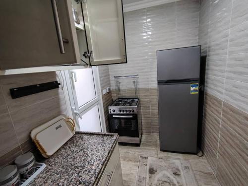 a small kitchen with a refrigerator and a stove at مدينتي in Kafr Salīm