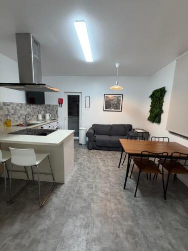 a kitchen and living room with a table and a couch at Casa do Fidalgo in Santiago do Cacém