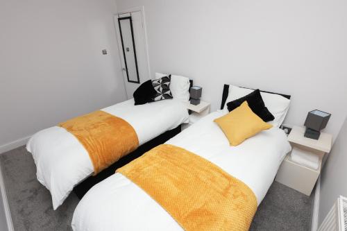 twee bedden naast elkaar in een kamer bij Modern 3 bedroom home refurbished with parking in Wednesbury