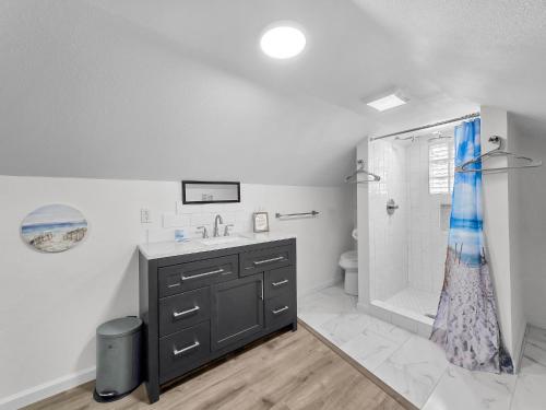 un bagno bianco con lavandino e doccia di Over the Rainbow a Crystal Beach