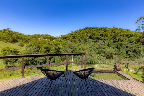 una panchina seduta sopra un ponte di legno di Chale Alcantara Jacuzzi, Lareira e Deck com Vista a São Pedro de Alcântara