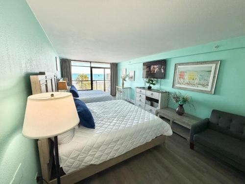 a bedroom with two beds and a television and a couch at Landmark resort in Myrtle Beach