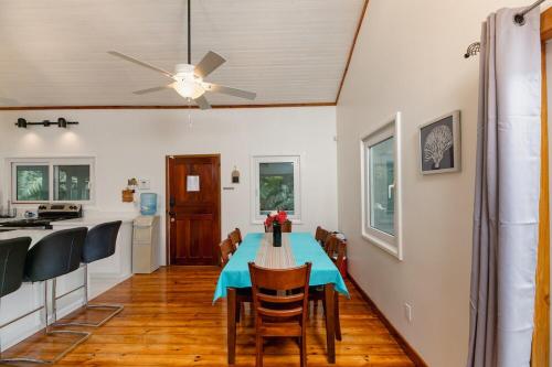 ein Esszimmer mit einem Tisch und einem Deckenventilator in der Unterkunft Casa Familia in West Bay